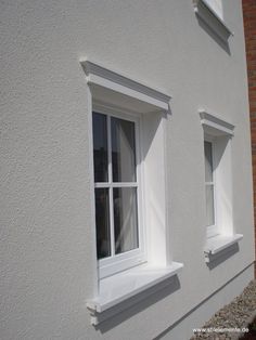 two white windows on the side of a building