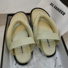 Color: Taupe Size: 6 Brand New, Just Tried Once. Designer Synthetic Sandals For Beach, Designer Toe Post Sandals For Spring, Flat Sandals With Padded Heel For Beach, Designer Leather Flip Flops For Summer, Designer Toe Post Sandals For Summer, Designer Cushioned Beach Sandals, Designer Summer Sandals With Cushioned Footbed, Designer Open Toe Flip Flops For Vacation, Designer Open Toe Flip Flops For Spring