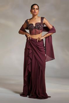 Wine georgette pre-draped saree with ruffle detailing and a side slit. Paired with a corset padded blouse.
Component: 2
Pattern: Embroidery
Type Of Work: Beads
Neckline: Notched
Sleeve Type: Sleeveless
Fabric: Corset: Satin and Lycra Mesh; Saree: Georgette
Color: Wine
Other Details: 
Beads embroidery
Notched neckline
Attached lining
Approx weight (in kg) : 1.2
Occasion: Destination Wedding - Aza Fashions Saree With Corset, Blouse Yoke, Corset Blouse, Ruffle Saree, Drape Saree, Saree Designs Party Wear, Embellished Blouse, Indian Couture, Beaded Neckline