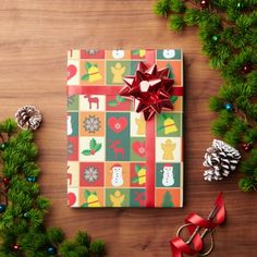 a christmas present wrapped in brown paper with red ribbon and bows on top of it