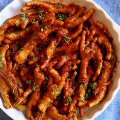 a white bowl filled with chicken wings covered in sauce