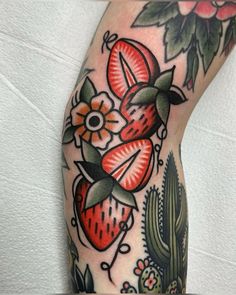 a close up of a person's leg with tattoos on it and flowers in the background