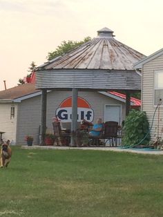 a dog running in front of a building with a grill on it's roof