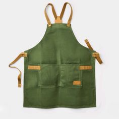 a green apron with two straps hanging from the front, and an open pocket on the back