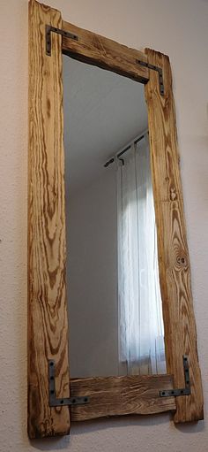 a wooden mirror hanging on the wall