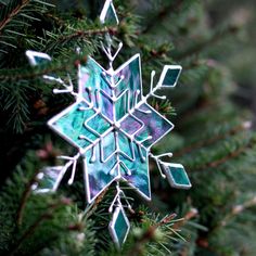 a snowflake ornament hanging from a christmas tree