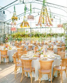 an outdoor dining area with tables, chairs and chandeliers hanging from the ceiling