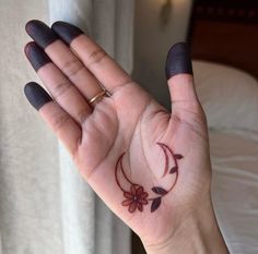 a woman's hand with a small tattoo on the middle of her left palm