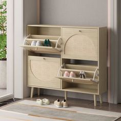 a wooden cabinet sitting in front of a sliding glass door next to a potted plant