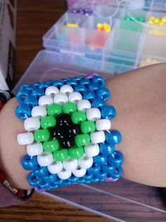 a close up of a person's hand wearing a bracelet made out of beads