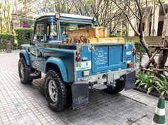 an old blue truck is parked on the street