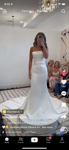 a woman in a white wedding dress is taking a selfie with her cell phone