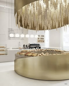 the interior of a pastry shop with gold and white decorations hanging from the ceiling above it