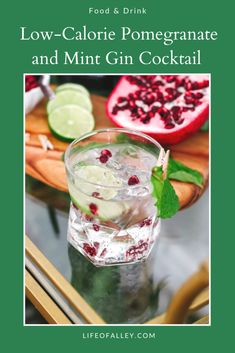 a glass filled with mint and pomegranate on top of a table