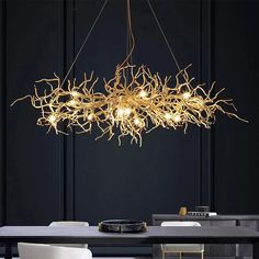 a modern chandelier hanging over a dining room table with chairs and a black wall in the background