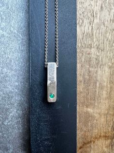 "Unique Silver Bar Textured Pendant Necklace For Men, Unique Emerald Silver Jewelry, Handmade by OmriGoren. This is a 925 sterling silver necklace and a hand-made textured silver bar pendant. A beautiful piece of raw emerald is held in a frame set as a centerpiece. This truly Unique Bar Necklace For Men is the perfect piece of jewelry for meaningful events Or everyday outfits, an art piece that cannot be ignored! My new unique men's jewelry collection combines metals and gemstones, creating a un Men Silver Jewelry, Unique Mens Necklace, Mens Pendant Necklace, Pendant Necklace Men, Mens Necklace Pendant, Raw Emerald, Anniversary Necklace, Bar Jewelry, Silver Bar Necklace