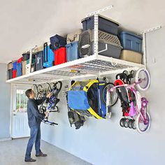 a man standing in front of a white wall filled with lots of luggage and bicycles