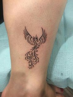 a woman's foot with a bird tattoo on the side of her leg,