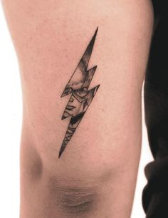 a black and white photo of a person's leg with a lightning tattoo on it