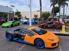 several different colored sports cars parked in a parking lot