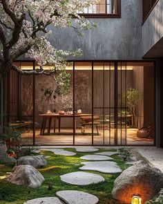 an outdoor area with stepping stones, grass and trees in the background is lit up by lanterns