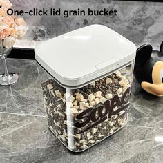 a mickey mouse figurine sitting on top of a counter next to a container filled with nuts