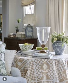 a living room filled with furniture and vases on top of a table next to a window