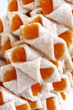 some kind of food that is sitting on a plate with powdered sugar and jelly