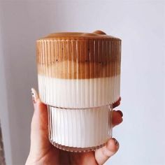 a woman holding a cup with coffee in it and her hand on the top one