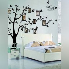 a white bed sitting under a tree with pictures on it