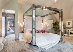 a bedroom with mirrored walls and a bed in the middle, surrounded by pillows and rugs