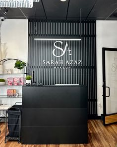 the front desk of a hair salon with black and white decor on it's walls