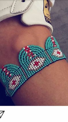 a close up of a person's arm with beaded bracelets on it