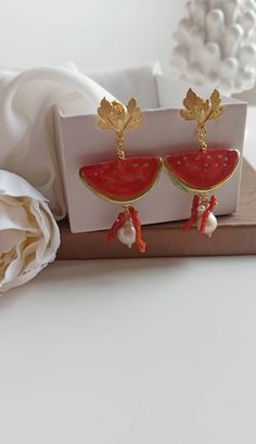 Sicilian earrings made of: - Sicily Ceramic Watermelon (30 mm x 17 mm); - Red Coral branches; - Baroque Pearls, white color; - Brass earrings, leaf shape. Lenght : 7 cm / 2,76 inches * SHIPPING * Your order will be shipped within 1-3 business days from your purchase. You can choose between 2 shipping methods: STANDARD SHIPPING (without tracking) or REGISTERED MAIL (with tracking). Each chapeau atelier jewel is shipped in a gift box. Thank you for your visit. Purple Heart Earrings, Watermelon Earrings, Square Earrings Studs, Square Stud, Purple Stones, Brass Earrings, Red Coral, Leaf Shapes, Baroque Pearls