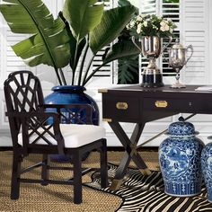 two blue and white vases sitting on top of a table next to a chair