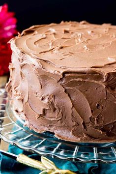 a chocolate frosted cake sitting on top of a glass plate