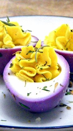 three deviled eggs with macaroni and cheese in them on a white plate