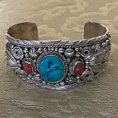 Intricately Styled Sterling Silver Cuff Bracelet Accented With A Large Genuine Turquoise And Two Smaller Genuine Coral Stones. Slightly Flexible, The Sterling Portion Of The Cuff Measures 6” Plus A 1 1/4” Opening - Fits A 7”-7 1/2” Wrist, With A Width Of 1 3/8”. Stamped “Sterling” With The Artisan’s Name “Hackett.” Suitable For Man Or Woman. New. Turquoise Bangle Cuff Bracelet For Formal Occasions, Elegant Turquoise Cuff Bracelet, Coral Stone, Sterling Silver Cuff Bracelet, Genuine Turquoise, Coral Turquoise, Sterling Silver Cuff, Silver Cuff Bracelet, Silver Cuff