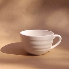 a white cup sitting on top of a table