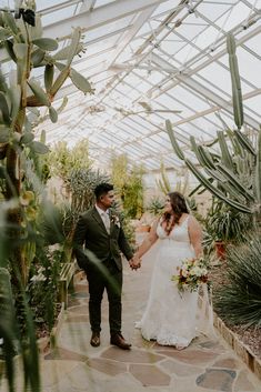 a bride and groom holding hands in a greenhouse