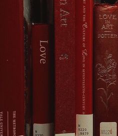 several red books are lined up on a shelf