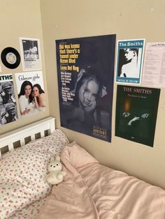 a bedroom with posters on the wall and a small bed in front of it's headboard