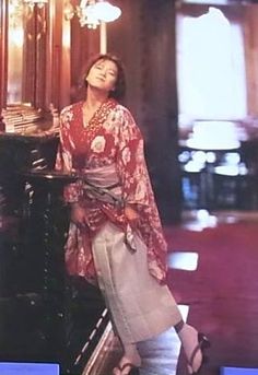 a woman standing next to an old piano