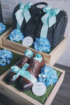 two wooden boxes filled with blue flowers and shoes on top of each other, one holding a black bag