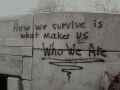 graffiti written on the side of a building that says how we survive is what makes us who we are