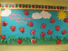 a bulletin board with ladybugs and clouds on it in a school classroom setting