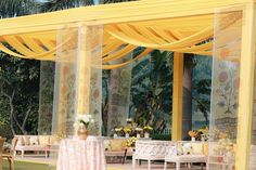 an outdoor wedding setup with yellow drapes