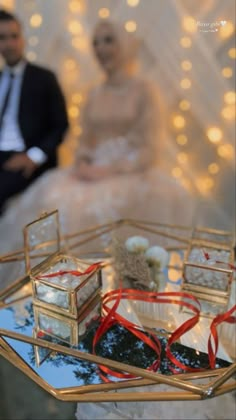 the bride and groom are sitting next to each other in front of a glass table