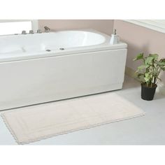 a white bath tub sitting next to a potted plant