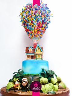 there is a cake that has been decorated with candy and balloons on top of it